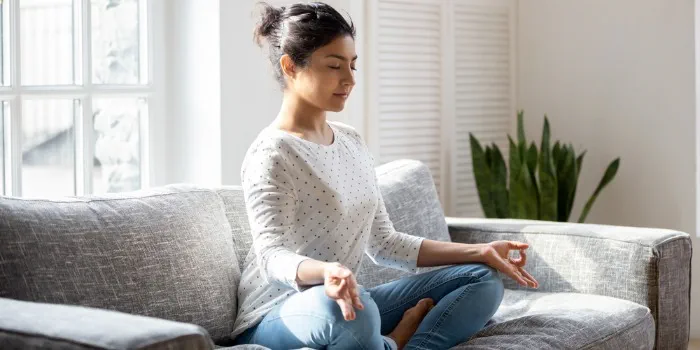Woman meditating on a sofa